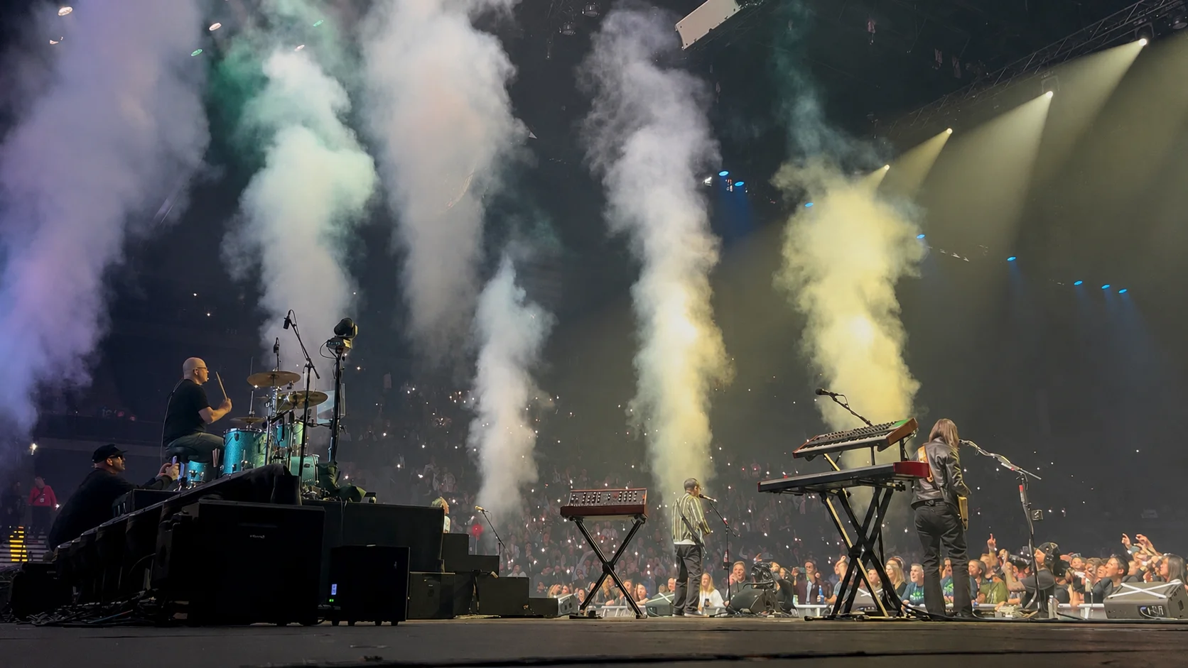 Live concert stage with colored smoke and crowd